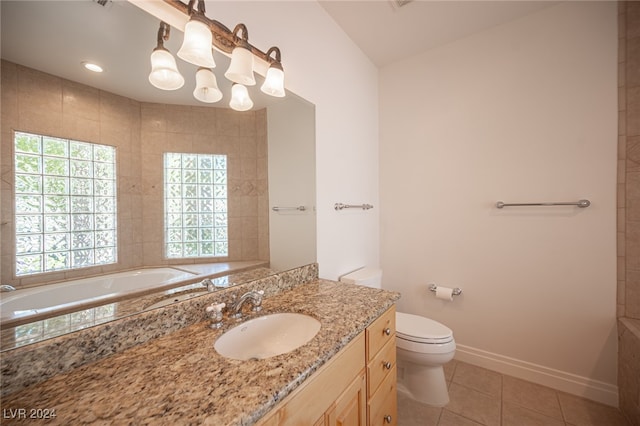 bathroom with vanity, toilet, a tub to relax in, and tile patterned flooring