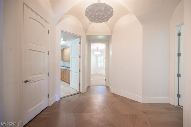 corridor with lofted ceiling and light wood-type flooring