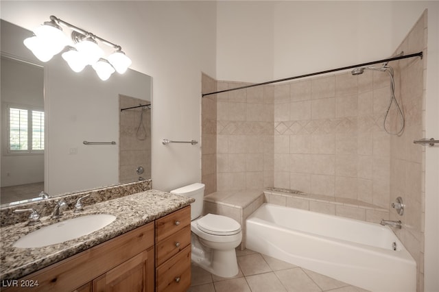 full bathroom featuring vanity, toilet, tiled shower / bath combo, and tile patterned flooring