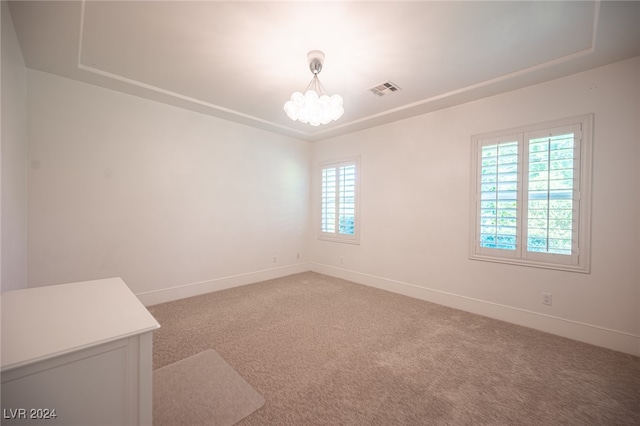 carpeted empty room featuring an inviting chandelier and a healthy amount of sunlight