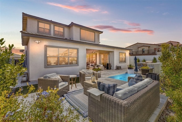 back house at dusk with a patio area and an outdoor hangout area