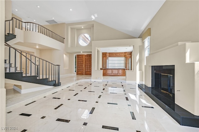 foyer with a fireplace and high vaulted ceiling