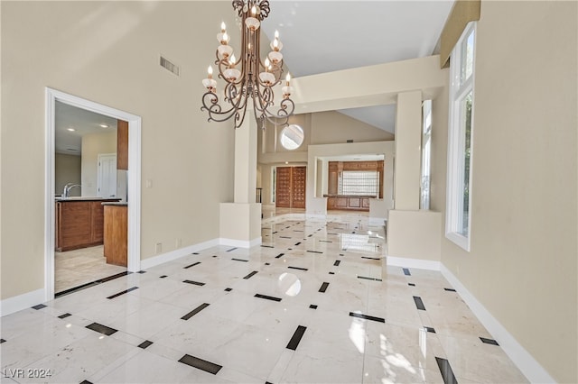 interior space with an inviting chandelier, high vaulted ceiling, and sink