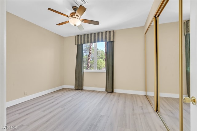 unfurnished bedroom featuring a closet, light hardwood / wood-style floors, and ceiling fan