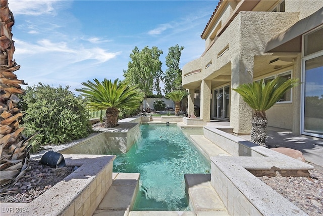 view of swimming pool featuring pool water feature and a patio area