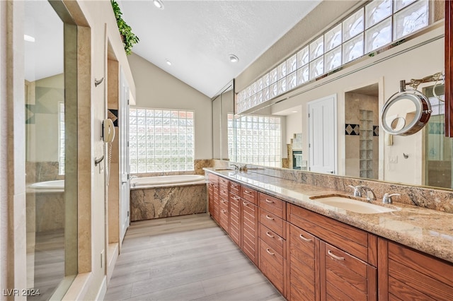 bathroom featuring high vaulted ceiling, shower with separate bathtub, hardwood / wood-style flooring, and vanity