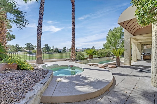 view of pool with a patio and an in ground hot tub