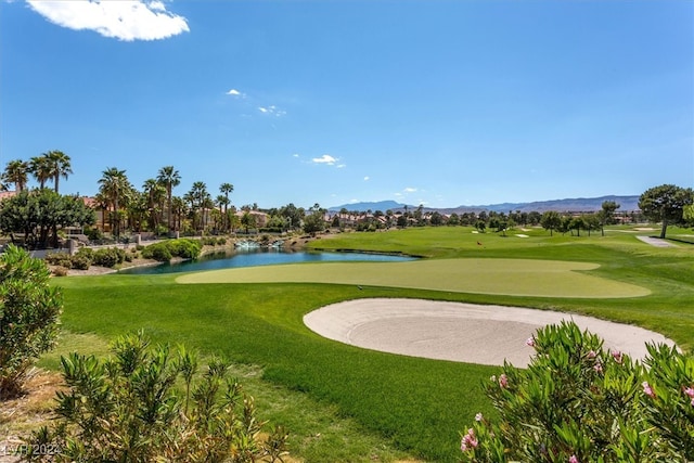 view of property's community with a lawn and a water and mountain view