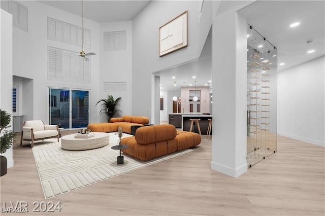 living room featuring light wood-type flooring and a high ceiling