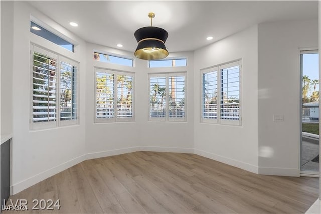 unfurnished dining area featuring light wood-type flooring and plenty of natural light