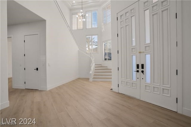 entrance foyer with a notable chandelier, light hardwood / wood-style floors, and ornamental molding