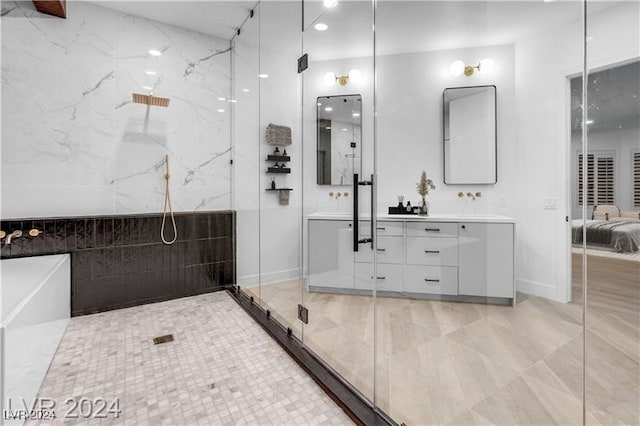 bathroom with walk in shower, vanity, and tile walls