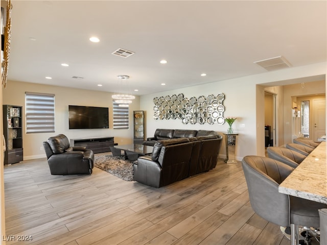 living room featuring a chandelier and light hardwood / wood-style floors