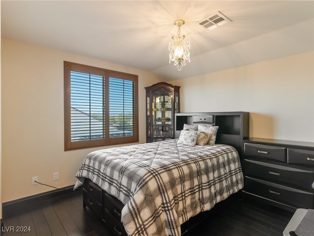 bedroom with an inviting chandelier and dark wood-type flooring