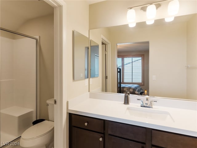 bathroom with a shower with door, vanity, and toilet