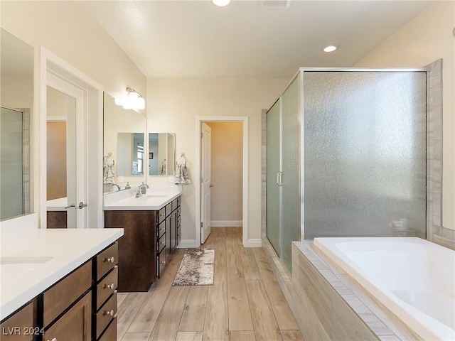 bathroom with hardwood / wood-style flooring, vanity, and separate shower and tub