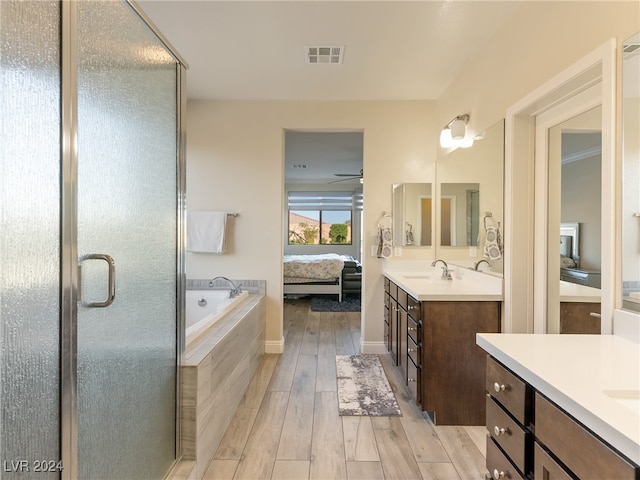 bathroom featuring vanity, ceiling fan, hardwood / wood-style floors, and plus walk in shower