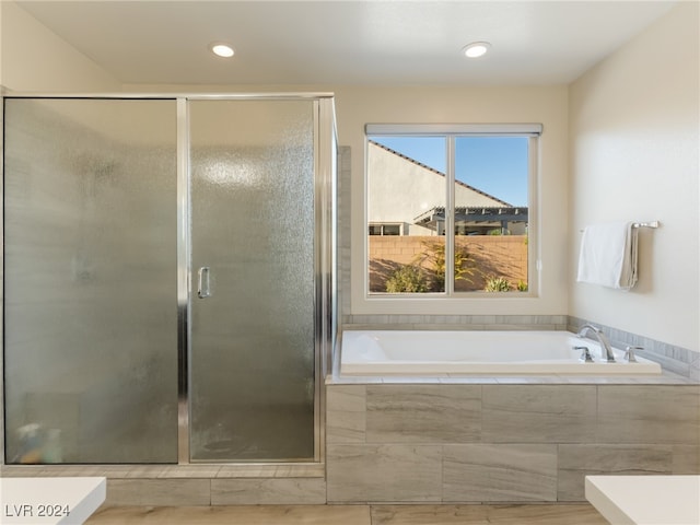 bathroom with hardwood / wood-style floors and separate shower and tub