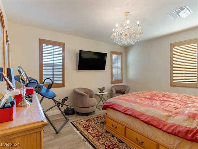 bedroom featuring a chandelier and light hardwood / wood-style floors