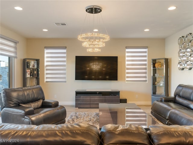 living room with light wood-type flooring and a notable chandelier