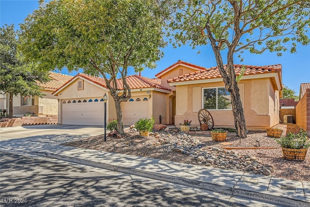 view of front of property featuring central air condition unit and a garage