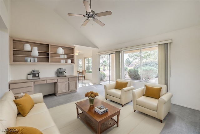 carpeted living room with ceiling fan and high vaulted ceiling