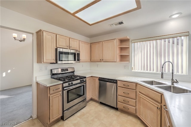 kitchen with light brown cabinets, light colored carpet, sink, and stainless steel appliances