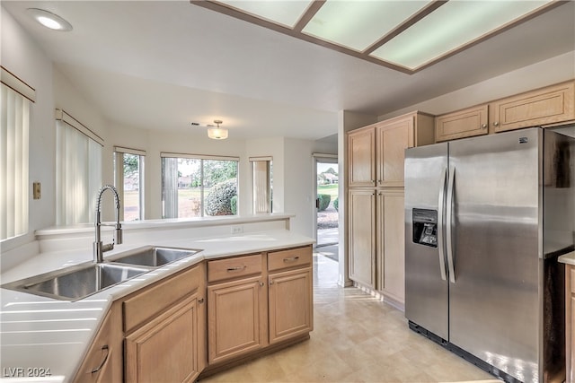 kitchen with light brown cabinetry, stainless steel fridge with ice dispenser, and sink