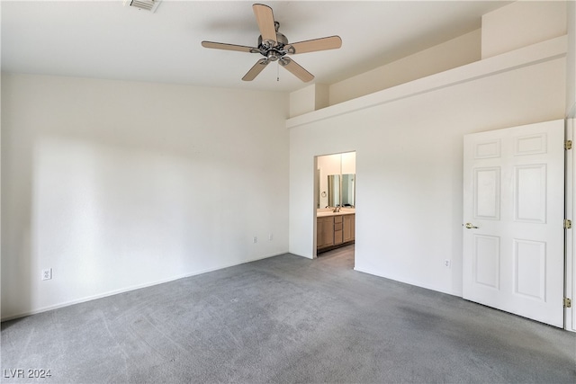 empty room with ceiling fan, a towering ceiling, and carpet