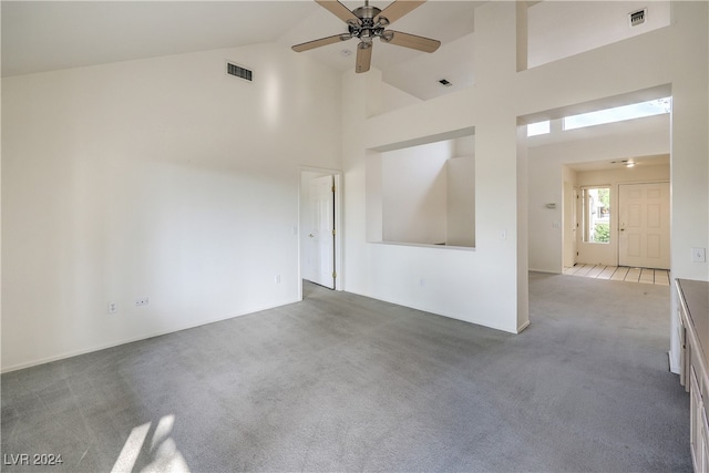 empty room featuring ceiling fan, carpet, and high vaulted ceiling