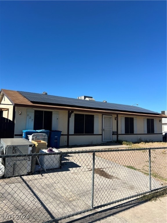 single story home featuring solar panels