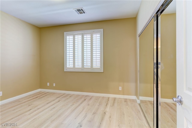 unfurnished bedroom with a closet and light hardwood / wood-style floors