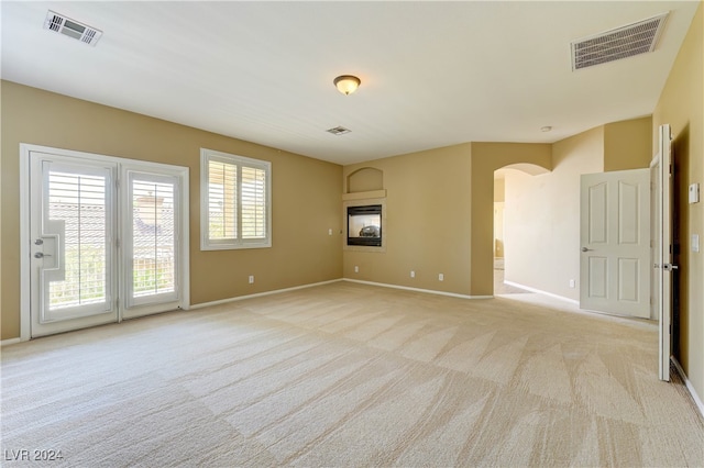 spare room featuring light carpet