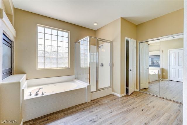 bathroom featuring wood-type flooring and independent shower and bath