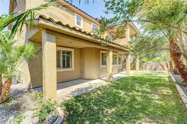 back of property with a yard and a patio area