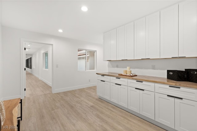 kitchen featuring light wood-type flooring, white cabinetry, and wooden counters