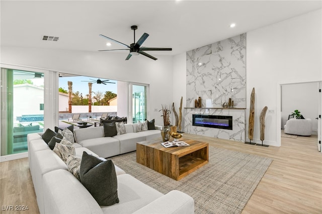 living room with light hardwood / wood-style flooring, a wealth of natural light, and a fireplace