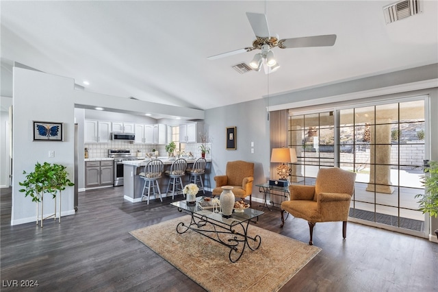 living room with lofted ceiling, ceiling fan, and dark wood-type flooring