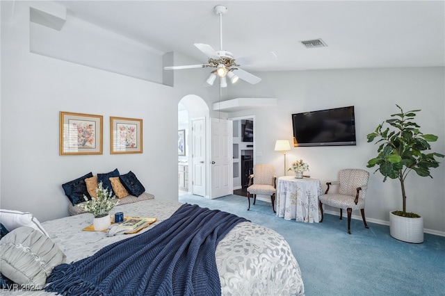 carpeted bedroom featuring connected bathroom, lofted ceiling, a fireplace, and ceiling fan