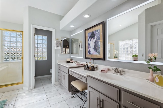 bathroom featuring vanity, tile patterned floors, toilet, and a healthy amount of sunlight