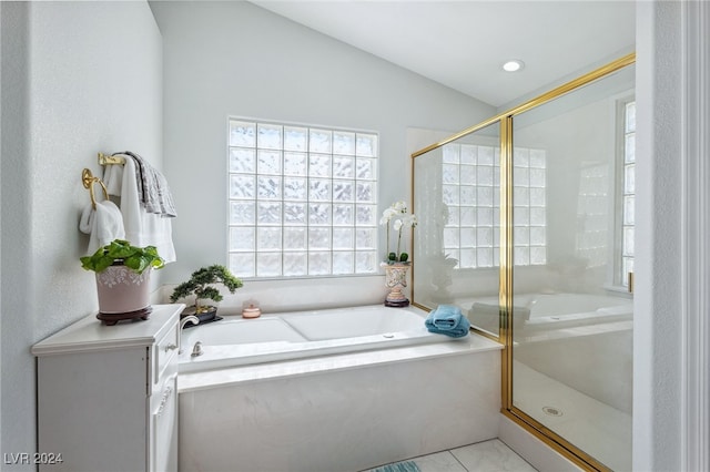 bathroom with shower with separate bathtub, lofted ceiling, and tile patterned floors