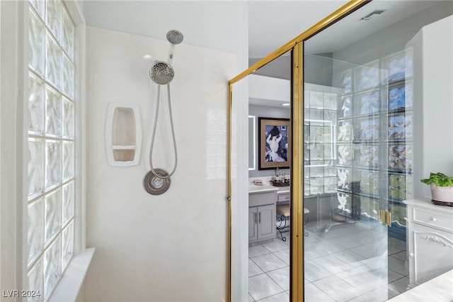 bathroom with walk in shower, tile patterned flooring, and vanity