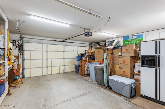 garage with white refrigerator with ice dispenser and a garage door opener