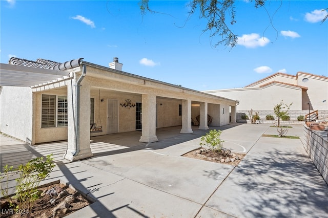 rear view of house featuring a patio and a pergola