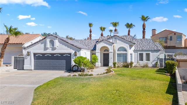 mediterranean / spanish-style house featuring a garage and a front lawn