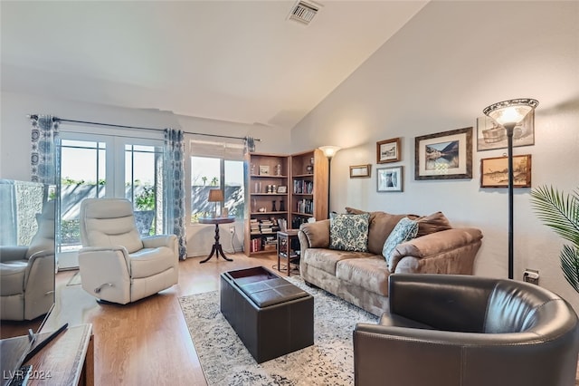 living room with high vaulted ceiling and hardwood / wood-style flooring