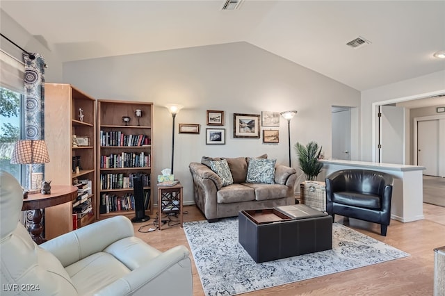 living room featuring light hardwood / wood-style flooring and vaulted ceiling