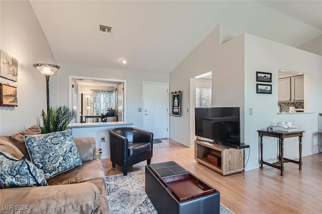 living room featuring light wood-type flooring and lofted ceiling