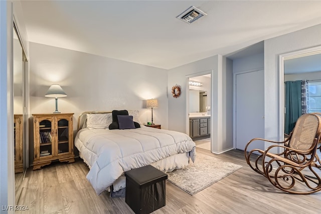 bedroom featuring light wood-type flooring and ensuite bathroom