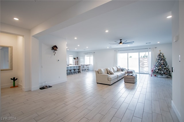 unfurnished living room featuring ceiling fan and light wood-type flooring